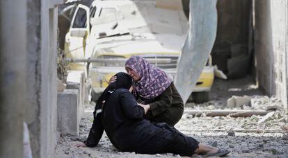 Duas mulheres choram ante os escombros de sua casa em Gaza. (AP)