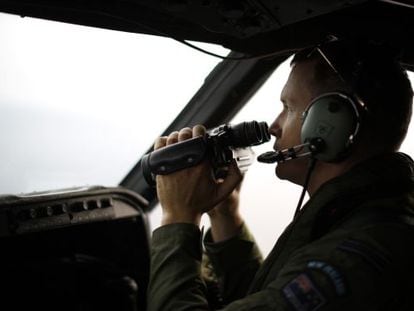 Um piloto da força aérea da Nova Zelândia busca restos do MH370.