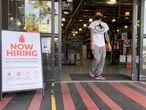 LARKSPUR, CALIFORNIA - APRIL 02: A customer walks by a now hiring sign at a BevMo store on April 02, 2021 in Larkspur, California. According to a report by the Bureau of Labor Statistics, the U.S. economy added 916,000 jobs in March and the unemployment rate dropped to 6 percent. Leisure and hospitality jobs led the way with 280,000 new jobs followed by restaurants with 176,000 jobs and construction with 110,000 new positions.   Justin Sullivan/Getty Images/AFP
== FOR NEWSPAPERS, INTERNET, TELCOS & TELEVISION USE ONLY ==