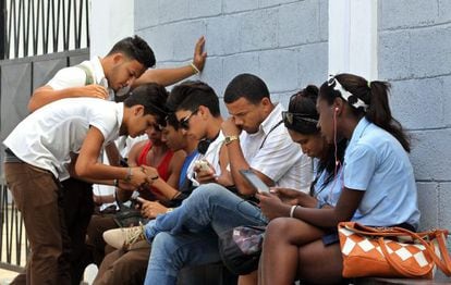 Jovens acessam a Internet no primeiro ponto de wifi gratuito de Cuba.