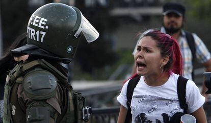 Uma manifestante discute com um carabineiro nos protestos de Santiago.
