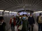 Passengers wearing face masks to prevent the spread of coronavirus, walk along a tunnel in a metro station in Barcelona, Spain, Wednesday, April 15, 2020. Spain has eased this week the conditions of Europe's strictest lockdown, allowing manufacturing, construction and other nonessential activity in an attempt to cushion the economic impact of the pandemic. (AP Photo/Emilio Morenatti)