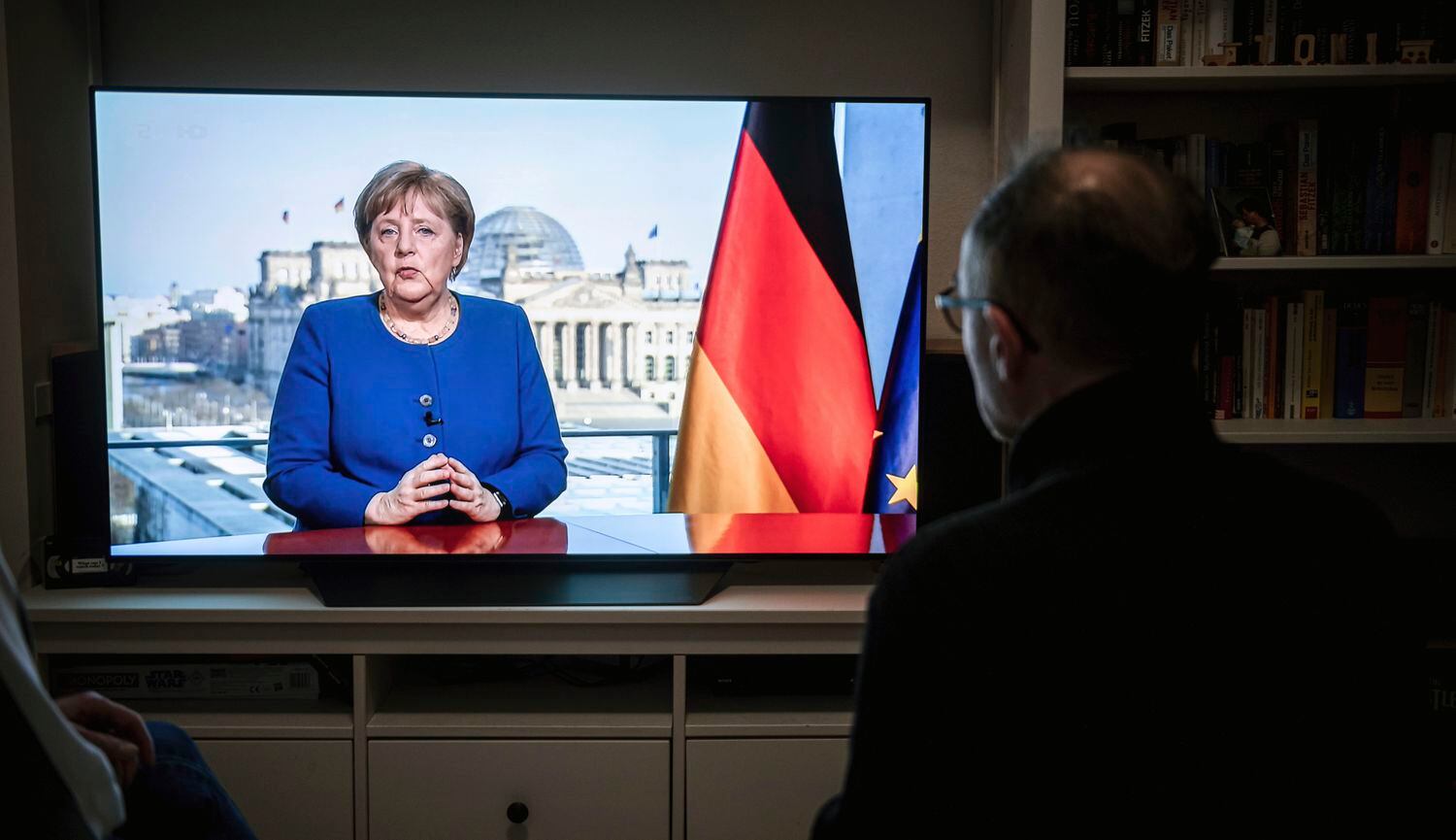 Alemão assiste a Merkel falar na TV.