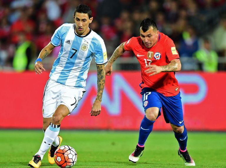 Di María tenta sair da marcação chilena.