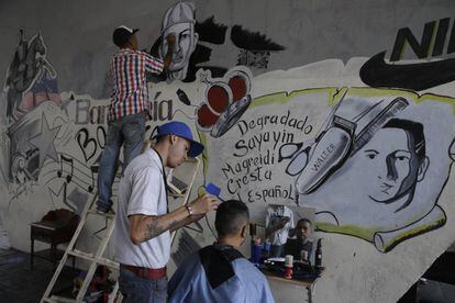 Gilbert Arteaga atende na sexta-feira um cliente em sua barbearia improvisada sob uma ponte em Caracas.