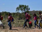 Venezuelanos caminham em Pacaraima, Brasil, depois de cruzar a fronteira.