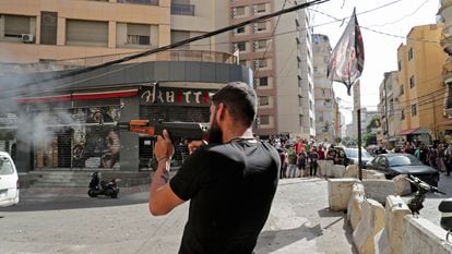 Um homem dispara sua arma no bairro de Tayuné durante os confrontos desta quinta-feira no Líbano.