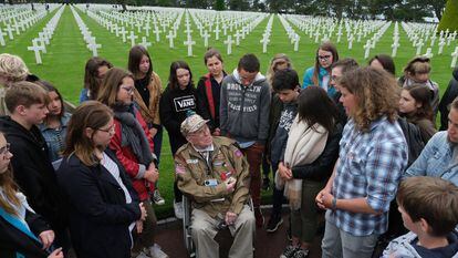 O combatente George Shenkle fala com estudantes franceses, nesta terça-feira no Cemitério Americano da Normandia.