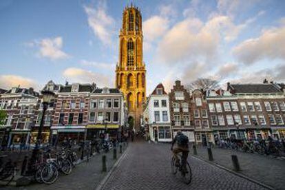 Ciclista passeia por uma rua cheia de bicicletas em Utrecht (Holanda).