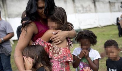 Uma mulher detenta com quatro de suas cinco crianças chora durante visita à Penitenciária Talavera Bruce no Rio de Janeiro, em 23 de Novembro de 2017.