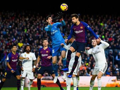 Courtois e Piqué disputam bola alta no primeiro clássico da temporada, no Camp Nou, quando o Barça venceu por 5 a 1.