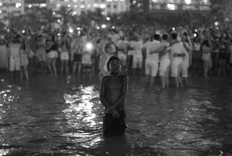 Um menino observa os fogos na virada de ano novo em Copacabana.