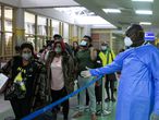 Nairobi (Kenya), 29/01/2020.- A Kenyan health worker (R) guides passengers to a health screening after they arrived from China, at Jomo Kenyatta International Airport in Nairobi, Kenya, 29 January 2020. African airports are on high alert after a suspected cases of cononavirus were detected in the Ivory Coast, Kenya and Ethiopia. (Costa de Marfil, Etiopía, Kenia) EFE/EPA/DANIEL IRUNGU