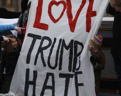 Manifestantes seguram o cartaz com o trocadilho &quot;Love Trumps Hate&quot; (O amor supera o &oacute;dio).