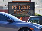 Automóviles pasan ante un signo de publicidad de Pfizer en Los Ángeles (California).