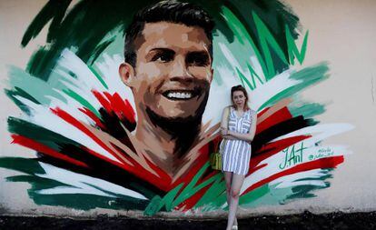 A artista Julia Antipova posa em frente ao mural que fez para Cristiano Ronaldo, em Saransk.
