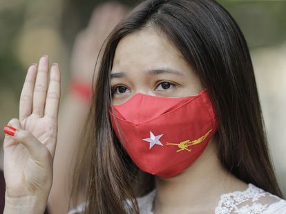 Manifestante com máscara do partido de Aung San Suu Kyi, no protesto deste sábado contra a junta militar em Yangon.