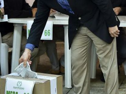 O ex-presidente Álvaro Uribe deposita seu voto na urna.