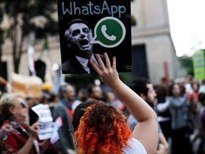 Uma mulher segura um cartaz, durante um protesto em São Paulo, contra suposto disparo em massa de notícias falsas em favor de Jair Bolsonaro.