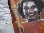 A viúva de Marielle Franco, Mônica Benício, ao lado de grafite da vereadora assassinada.