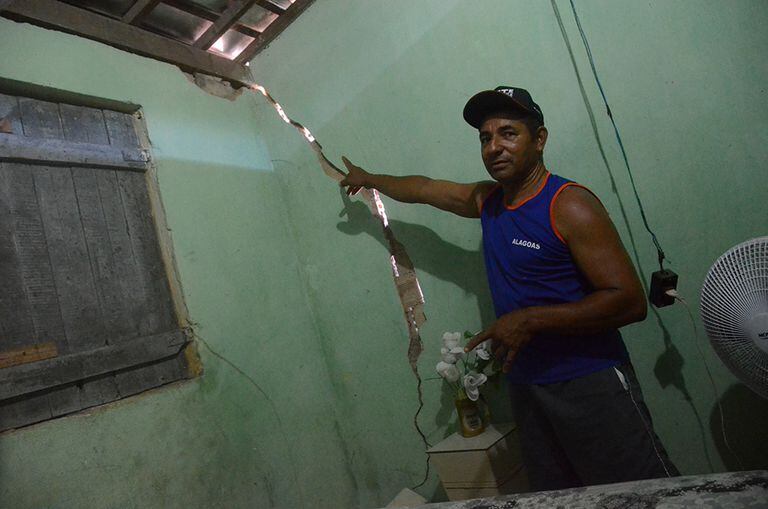 Jânio exibe as paredes rachadas de sua casa.