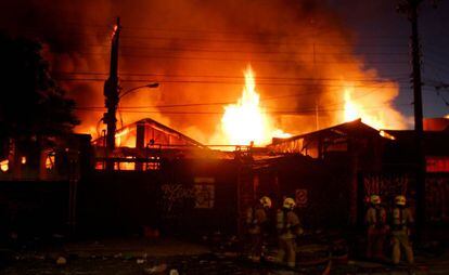 Bombeiros combatem incêndio em um armazém durante os distúrbios no Chile.