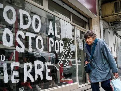 Mulher passa diante de loja em liquidação no dia 22 de agosto, em Buenos Aires. Em vídeo, imagens dos protestos na Argentina.