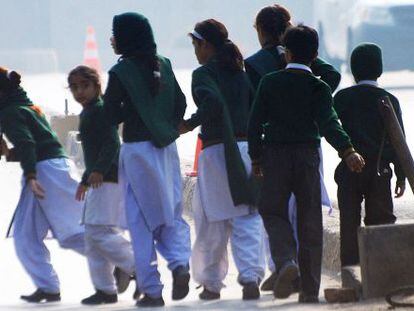 Grupo de estudantes da escola atacada em Peshawar (Paquistão) se afasta do lugar do atentado.
