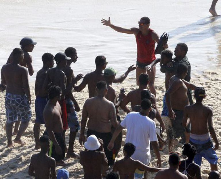 Ladrão e preso na praia e banhistas tentam resgatá-lo.
