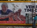A man fixes a billboard in support of former Brazilian president (2003-2011) Luiz Inacio Lula da Silva in downtown Rio de Janeiro, Brazil on April 29, 2021. (Photo by MAURO PIMENTEL / AFP)