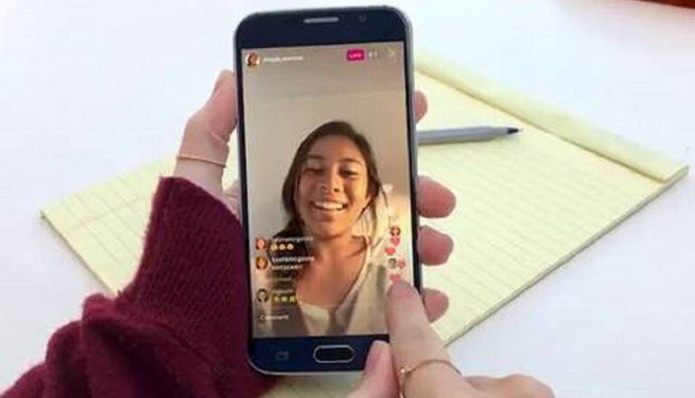 Uma adolescente consulta uma publicação em seu telefone.