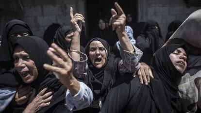 Mulheres palestinas no enterro de uma família morta em um bombardeio.