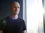 Brian Armstrong, co-founder and chief executive officer of Coinbase Inc., stands for a photograph at the Coinbase Inc. office in San Francisco, California, U.S., on Friday, Dec. 1, 2017. Coinbase wants to use digital money to reinvent finance. In the company's version of the future, loans, venture capital, money transfers, accounts receivable and stock trading can all be done with electronic currency, using Coinbase instead of banks. Photographer: Michael Short/Bloomberg
