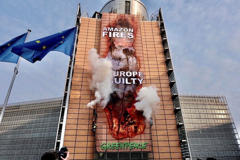 Ação feita neste mês pelo Greenpeace na sede da Comissão Europeia para criticar o acordo comercial entre a UE e o Mercosul. No cartaz: "Fogo na Amazônia, Europa culpada".