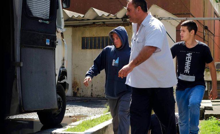 Um dos detidos (esquerda) pela suposta violação de uma menor é conduzido aos tribunais de Mar del Prata, na província de Buenos Aires