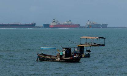 Pescadores na praia de Gaibu (PE), com os navios no porto de Suape ao fundo.