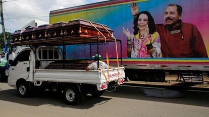Um caminhão com caixões passa diante de um cartaz do casal presidencial em Masaya, Nicarágua, em 2 de novembro.