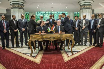 O representante do Fatah, Azzam al-Ahmad (na mesa, à direita) e o líder do Hamas, Salah al-Aruri (à esquerda), assinam a reconciliação no Cairo, na quinta-feira.