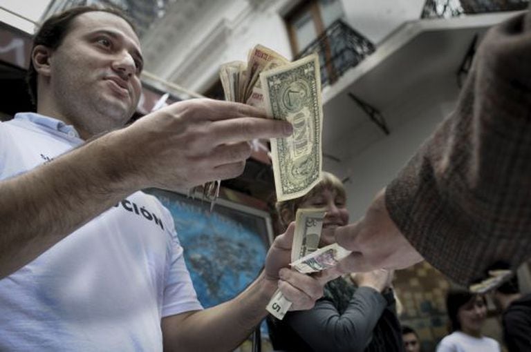Um político opositor do Governo argentino imita a venda de dólares no mercado negro.