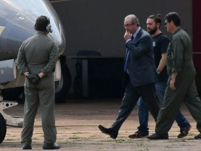 Preso, Eduardo Cunha é levado para avião da PF.