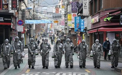 Soldados sul-coreanos desinfetam uma rua de Seul.