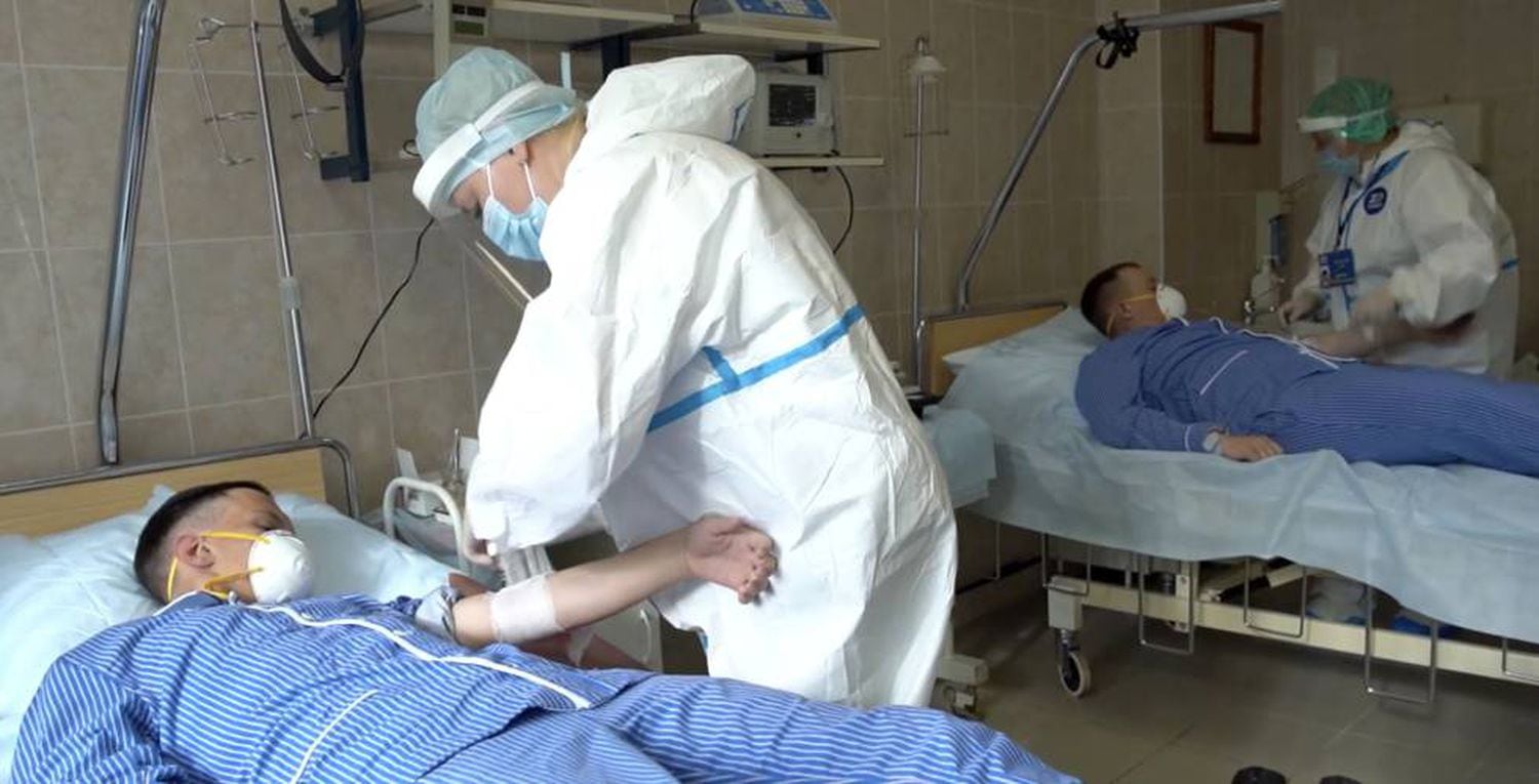 Trabalhadores fazem exame de sangue em pacientes em hospital militar da Rússia.