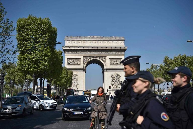 Policiais franceses patulham a Champs Élysées, em Paris, um dia após o atentado.