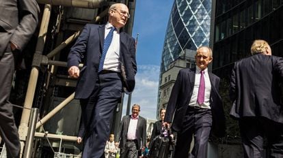 Funcionários caminhando por rua do distrito financeiro de Londres.