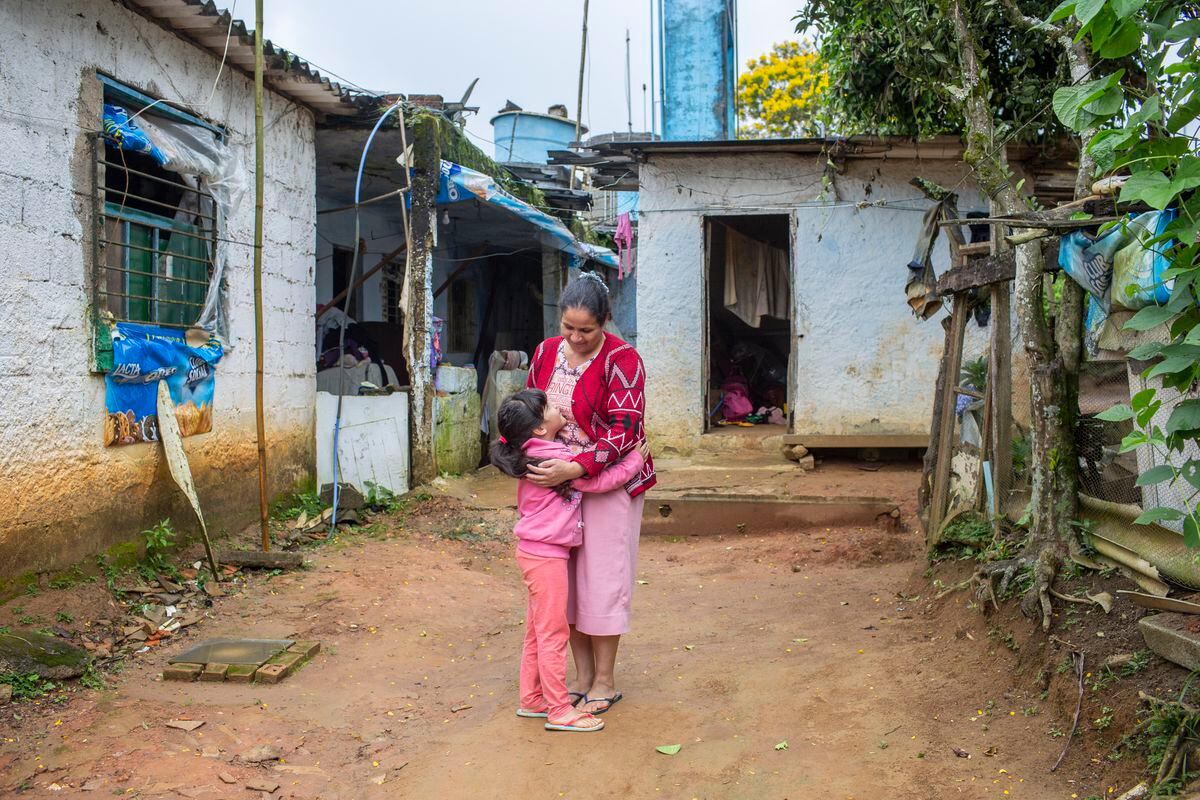 Menina criança 5 anos fica na rua perto da cerca trançada com