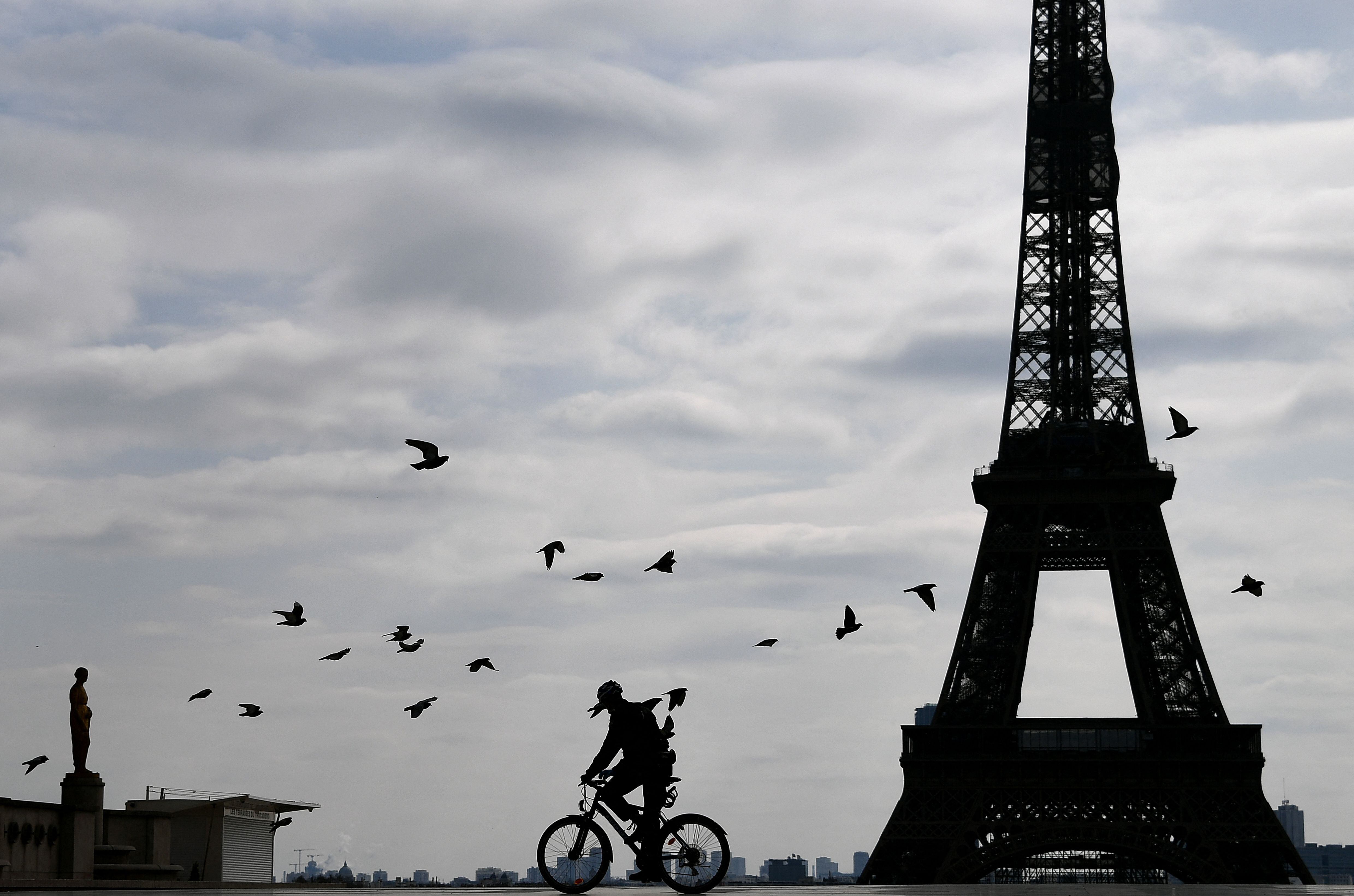 Um ciclista pedala pelo bairro de Trocadero, perto da Torre Eiffel, em Paris. 