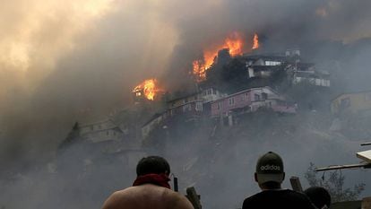 Vários homens contemplam o incêndio na serra Rocuant, de Valparaíso, na noite de terça-feira.
