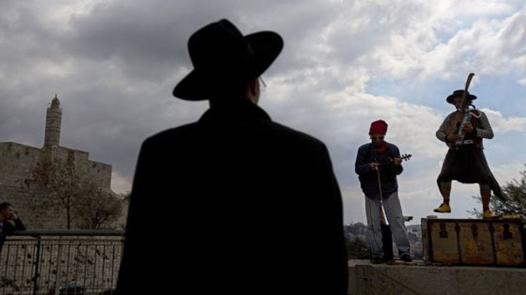 Um judeu ultraortodoxo observa uma apresentação musical em Jerusalém.