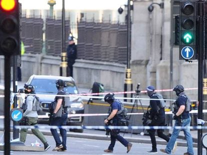 Agentes da policial antiterrorismo atravessam a zona isolada nesta quarta-feira na Ponte de Westminster, em Londres, em proximidade da sede do Parlamento britânico.