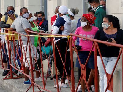 Personas con tapabocas hacen fila en febrero para comprar alimentos en un mercado de La Habana
